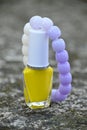 closeup the yellow white color nail paint glass bottle with white purple bracelet soft focus natural grey brown background Royalty Free Stock Photo