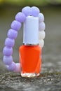 closeup the yellow white color nail paint glass bottle with white purple beads bracelet soft focus natural grey brown background Royalty Free Stock Photo