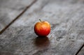 Closeup of a yellowish-red apple on the wooden surface.