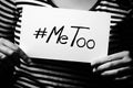 Young adult woman holding a sign with the hashtag MeToo