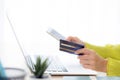 Closeup young asian business woman using smart phone and holding credit card while online shopping and payment with laptop. Royalty Free Stock Photo