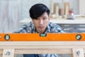 Closeup young asian carpenter working on wooden job with spirit level Royalty Free Stock Photo