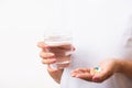 Woman hold pill drugs in hand ready take medicines with a glass of water