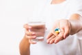 Woman hold pill drugs in hand ready take medicines with a glass of water