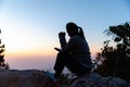 Closeup of a young asian woman praying, against abstract sunrise background. Silhouette of woman kneeling down praying for worship