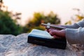 Closeup of a young asian woman praying, against abstract sunrise background. Silhouette of woman kneeling down praying for worship Royalty Free Stock Photo