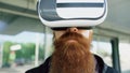Closeup of Young bearded man using virtual reality headset for 360 VR experience and take of glasses smiling outdoors Royalty Free Stock Photo