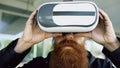 Closeup of Young bearded man using virtual reality headset for 360 VR experience and take of glasses smiling outdoors Royalty Free Stock Photo