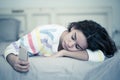 Portrait of a bored, unhappy and tired pretty young girl using mobile phone in bed Royalty Free Stock Photo