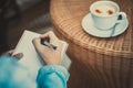 Closeup of a young business woman write a book for work and drinking some coffee Royalty Free Stock Photo