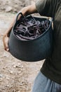 Farmer carrying a basket full of carob beans