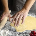 closeup of a young caucasian man kneading a piece of dough to prepare a coca de cireres, a cherry sweet flat cake typical of