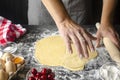 closeup of a young caucasian man kneading a piece of dough to prepare a coca de cireres, a cherry sweet flat cake typical of