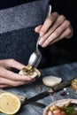 Man putting some fried mushrooms on a bread bun