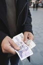 Man offering some czech koruna banknotes