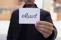 Man showing a note with the hashtag resist