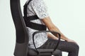 Man wearing a posture corrector while sitting