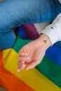 Closeup of young caucasian millennial hippie woman with painted rainbow flag in heart shape painted in wrist. Rainbow