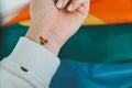 Closeup of young caucasian millennial hippie woman with a rainbow flag in heart shape painted in wrist. Rainbow color