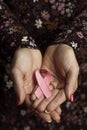 Young woman with a pink ribbon in her hands