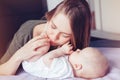 Young Caucasian woman mother hugging kissing playing with cute newborn baby boy girl child at home. Royalty Free Stock Photo