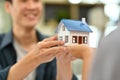 Closeup young couple hands holding a house model. Buying property, real estate, loan and insurance Royalty Free Stock Photo