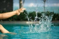 Close up young female leg make splash of blue water in swimming pool Royalty Free Stock Photo