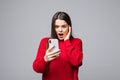 Closeup of young happy woman wearing in red sweater with mobile phone, over white background Royalty Free Stock Photo