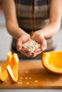 Closeup on young housewife showing pumpkin seeds Royalty Free Stock Photo