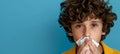 Closeup of a young ill boy blowing his nose into a tissue, providing ample space for text placement Royalty Free Stock Photo