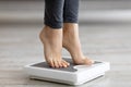 Closeup of young Indian woman standing on scales, measuring her weight indoors Royalty Free Stock Photo