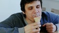 Closeup of young lousy man eats ice cream.