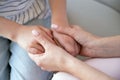 Closeup on young loving caring mother holding hands of kid girl