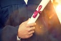 Closeup of young male student holding diploma on graduation day Royalty Free Stock Photo