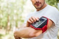 Closeup of young man athlete using mobile phone in handband Royalty Free Stock Photo