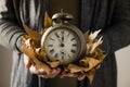 Man with old alarm clock and dry leaves Royalty Free Stock Photo