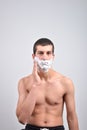 Closeup of young man preparing to shave, he puts foam on his c Royalty Free Stock Photo