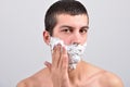 Closeup of young man preparing to shave, he puts foam on his c Royalty Free Stock Photo