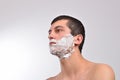 Closeup of a young man preparing to shave, he puts foam on his c Royalty Free Stock Photo