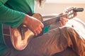 Closeup of a young man`s hands playing an acoustic guitar ukulele at the home. Man holding ukulele. Royalty Free Stock Photo