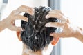 Closeup young man washing hair with with shampoo in the bathroom, vintage tone, selective focus Royalty Free Stock Photo