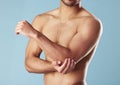 Closeup young mixed race man standing shirtless in studio isolated against a blue background. Unrecognizable topless