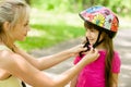Closeup young mother dresses her daughter's bicycle helmet Royalty Free Stock Photo