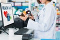 Closeup young pharmacist scanning barcode of mockup qualified pill bottle.