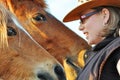 Closeup young pretty woman talking to two horses Royalty Free Stock Photo