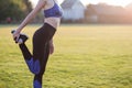 Closeup of young sportive woman doing exercise before running in morning field outdoors Royalty Free Stock Photo