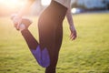 Closeup of young sportive woman doing exercise before running in morning field outdoors Royalty Free Stock Photo