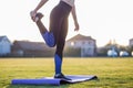 Closeup of young sportive woman doing exercise before running in morning field outdoors Royalty Free Stock Photo