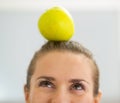 Closeup on young woman with apple on head