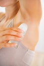 Closeup on young woman applying deodorant on underarm Royalty Free Stock Photo